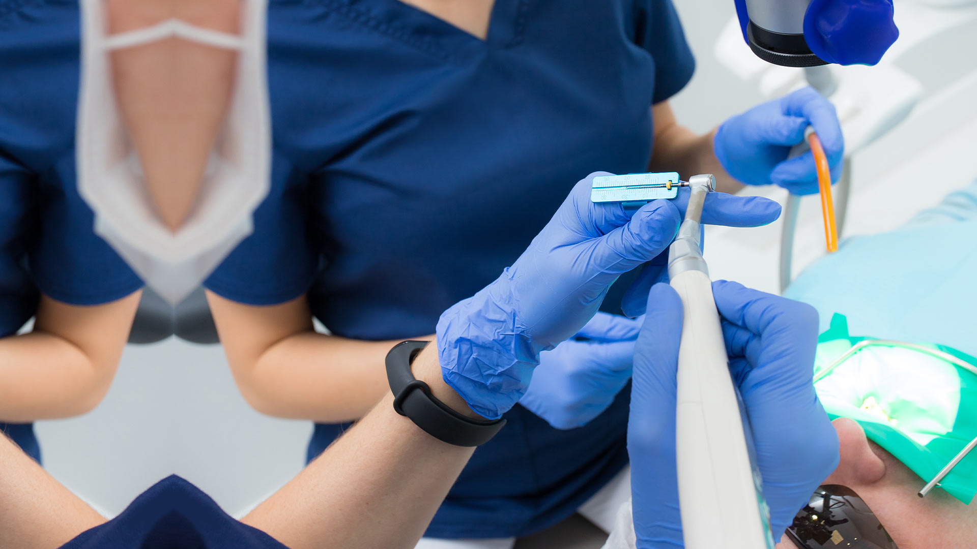 dentists performing root canal treatment to patient