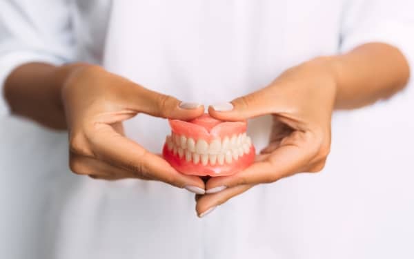 a dentist holding dentures