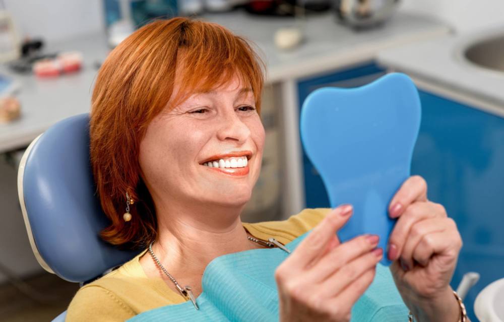 woman smiling after successful dentures treatment in dental clinic
