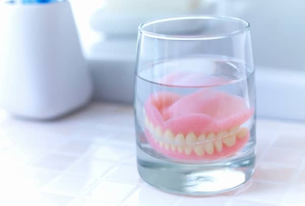 Soak your dentures in a denture cleanser or water when you take them out.