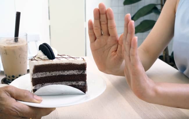 Woman saying no to a piece of cake