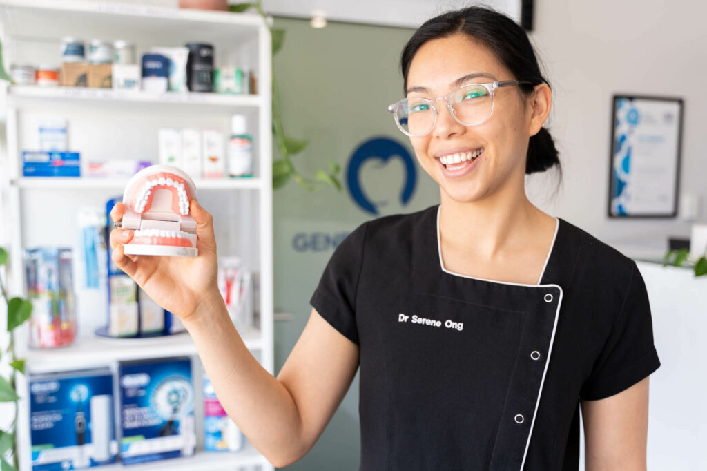 Serene holding a pair of dentures in our Canning Vale clinic
