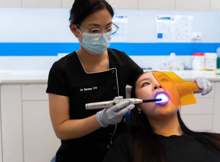 Serene performing teeth whitening on a patient