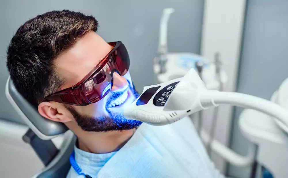 Man undergoing a professional teeth whitening procedure