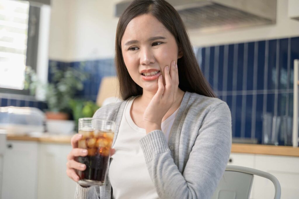 Woman drinking soda which can cause cavities
