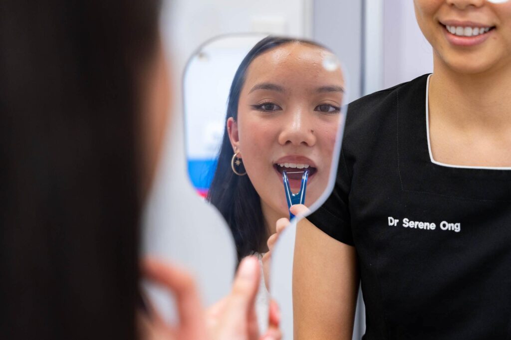 Woman flossing after wondering what are canker sores